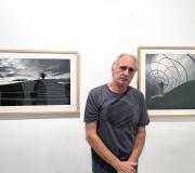 Plácido L. Rodríguez posa ante dos de sus fotografías