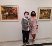 La viuda del artista, Marina Cañizo, posa con su hija, Marina Fernández, ante dos cuadros de la exposición.