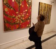 Unha muller contempla un dos cadros que, durante todo o mes de marzo, poderán visitarse na Casa de Galicia