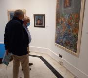 Un asistente contemplando una de las obras de la exposición de Celso Varela