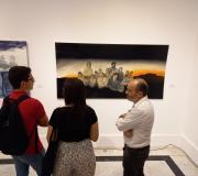 Los asistentes a la inauguración contemplan una de las obras de Gema López perteneciente a la serie "Translúcidas"