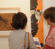 Dúas personas contemplan algunhas das obras con máis cor da exposición