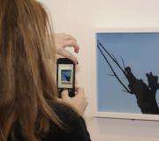 Unha rapaza captura co seu móbil unha fotografía da mostra