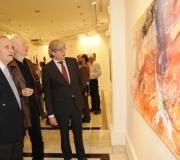 O delegado, o pintor e o embaixador ante un dos cuadros.