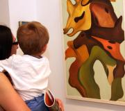 Unha moza mostra ao seu fillo unha pintura de Maquieira.