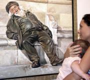 Unha moza observa o lenzo "o mendigo"