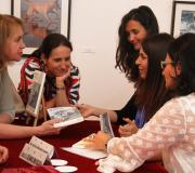 A autora, firmando exemplares