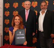 Paula mostra o Libro de Ouro da Casa, no que Pelaez e mais ela asinaron convidados polo delegado da Xunta José Ramón Ónega