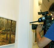 Un cámara de tv graba un dos cadros da mostra.