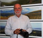 Xurxo Lobato posa coa súa cámara ante algunhas  das fotos panorámicas que integran a exposición.