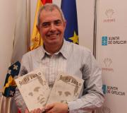 Afonso Eiré posa sorinte coas dúas edicions do seu libro, en galego e castelán.