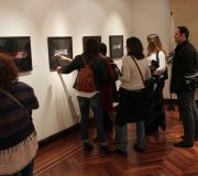 Parte do público observa a mostra que está da denominada Sala L da Casa de Galicia.