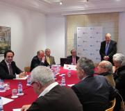 O delegado dela Xunta en Madrid, José Ramón Ónega, diríxese aos parpticipantes na reunión acompañado por Víctor Cortizo (á súa esda.) e Javier Serra (ao seu dta.).