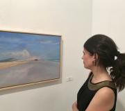 6. Unha moza observa a obra Corrubedo da pintora Carmen  Iglesias.