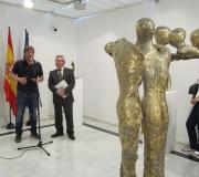 Miguel Couto intervindo na inauguración, xunto a Ramón Jiménez, coa obra "En femenino IV" penetrándose no plano.