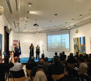 4. Lucía Espinosa de Mercado Hispano, o presidente de AEGAMA Julio Lage, e o coordinador de Actividades da Casa de Galicia na presentación da xenebra con parte do público que asistiu.