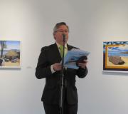 O coordinador de Actividades da Casa, Ramón Jiménez, presentando a mostra, con dúas das súas obras ao fondo..