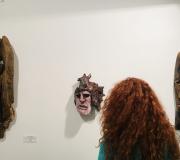 6. Unha moza observa atentamente obras do artista MOXOM.